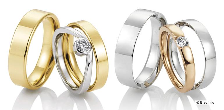 To smukke vielsesringe i guld og sølv med en diamant, præsenteret i et elegant arrangement.