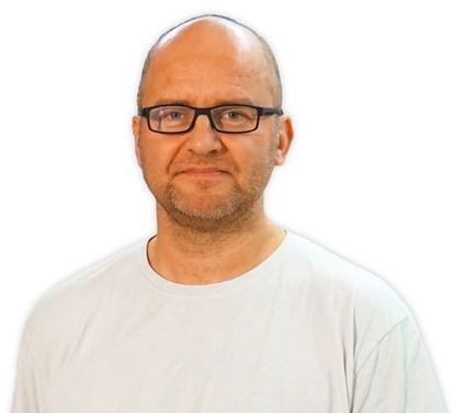 Mand med briller iført en lys t-shirt, står foran en hvid baggrund.
