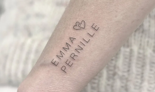Tatovering på underarmen med navnene "Emma" og "Pernille" samt et hjerte imellem.