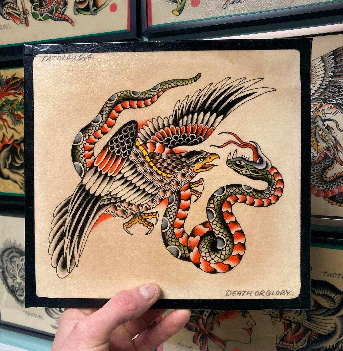 En farverig tatovering af en ørn, der kæmper mod en slange, med detaljerede mønstre og nuancer.