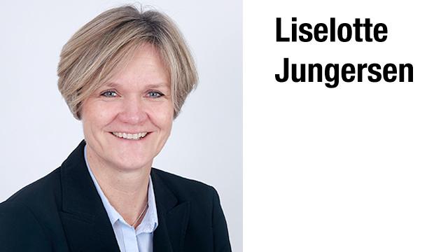 Professionelt portræt af Liselotte Jungersen med kort hår og smilende ansigt, iført en sort jakke.
