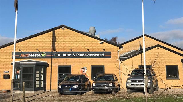 Auto- og pladeværkstedet T.A. Auto med flere biler parkeret foran bygningen.