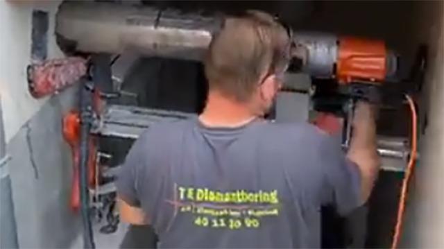 En håndværker arbejder med en elektrisk boremaskine i et byggeprojekt.