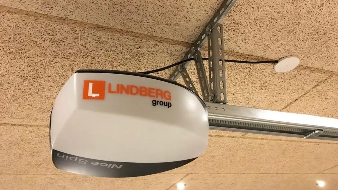 Lindberg gruppe garageportåbner hængende fra loftet med kabel og antenne synlig.
