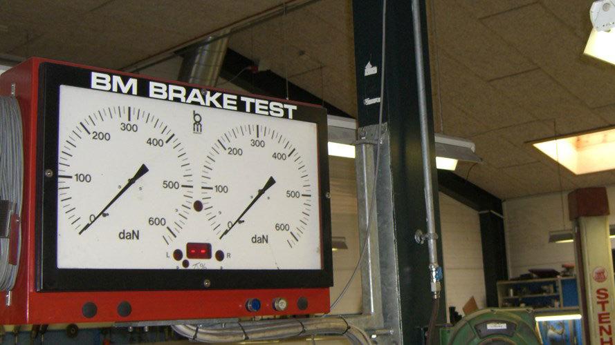Bremsetestapparat med to målere, der viser bremsetryk i en værkstedshal.