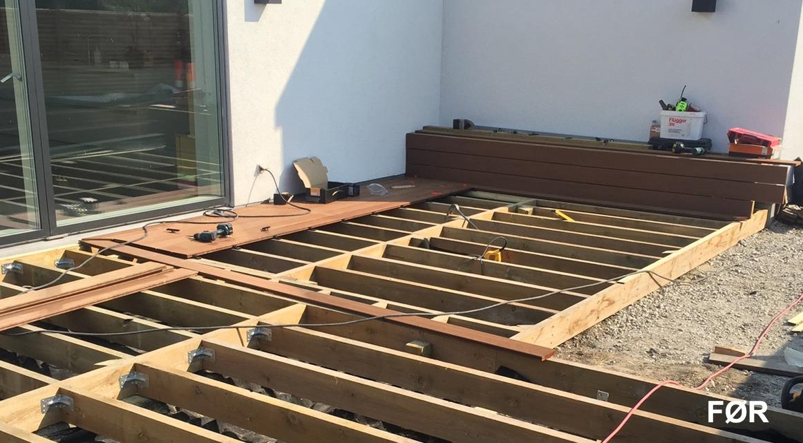 Billede af en terrasse under opbygning med trærammer og værktøj på stedet.