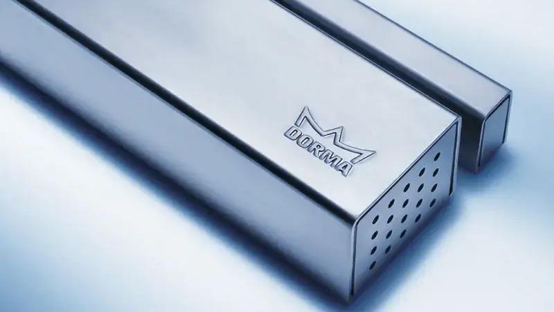 Et nærbillede af en metalrør med perforeringer og et logo, der viser et moderne design.