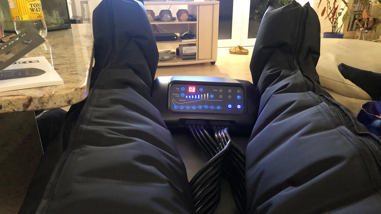 Fødder i en afslappende massageapparat med kontrolpanel og bløde benstøtter.