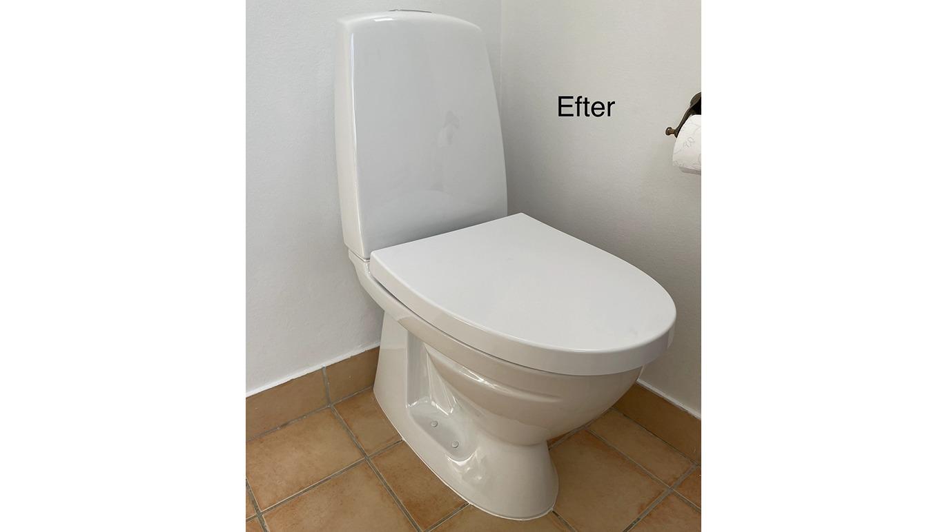 Toilet i hvidt design med lukket låg, placeret på flisebelagt gulv i et lyst badeværelse.