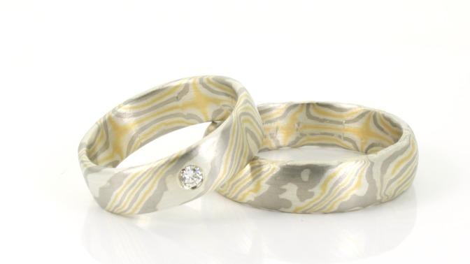 To smukke vielsesringe i sølv med et unikt mønster og en diamant i den ene ring.