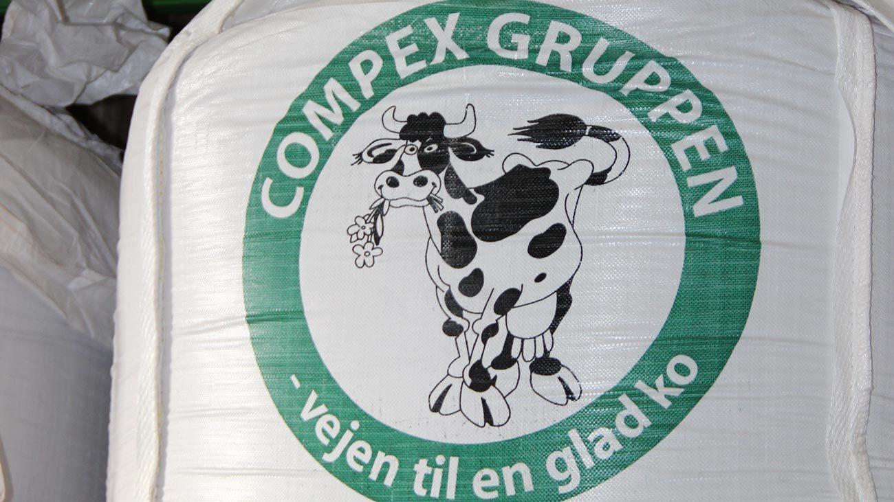 Balle med logo fra Compex Gruppen, der viser en glad ko med en gulerod i munden.