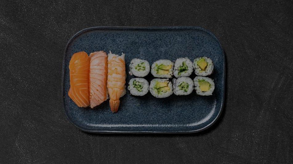 En blå tallerken med forskellige sushi-ruller og nigiri med laks.