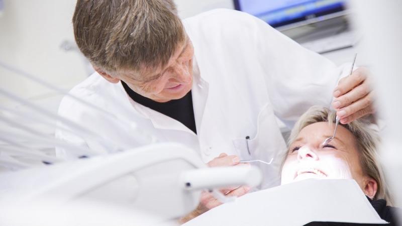 En tandlæge undersøger en patients tænder i en moderne tandklinik.