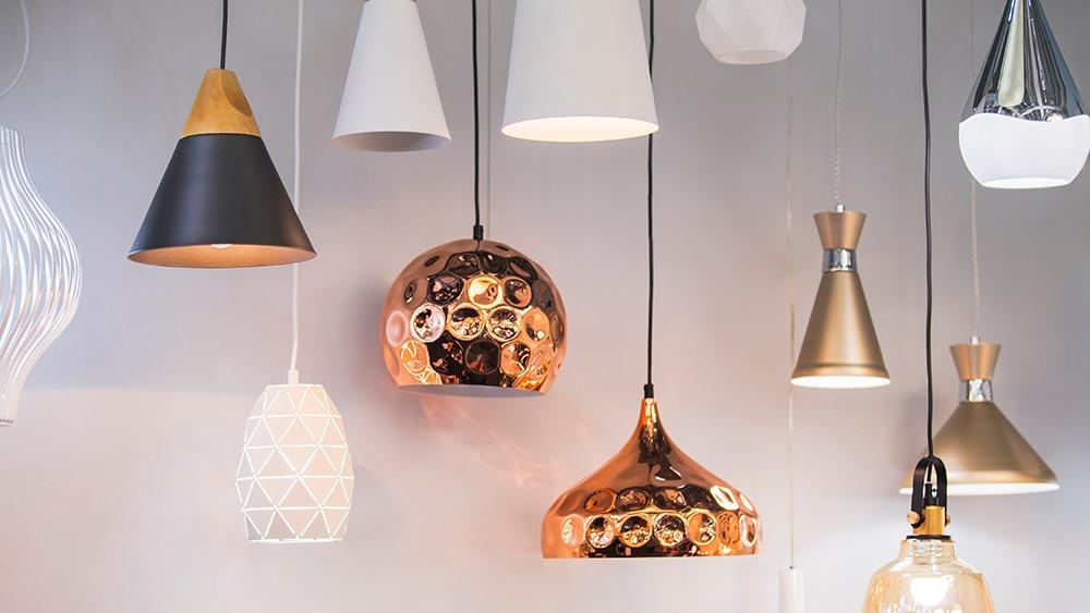 En samling af moderne loftlamper i forskellige former og farver, herunder kobber, hvid og sort.