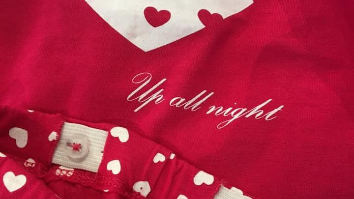 Rød pyjamas med hjerter og teksten "Up all night" på brystet.