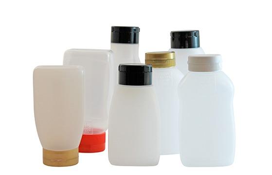Flere plastikflasker med forskellige låg og størrelser, ideelle til opbevaring af væsker.