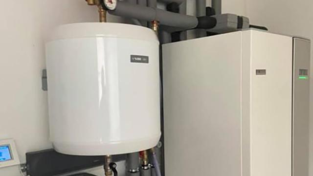 Varmtvandsbeholder og varmepumpe installeret i et moderne teknikrum.