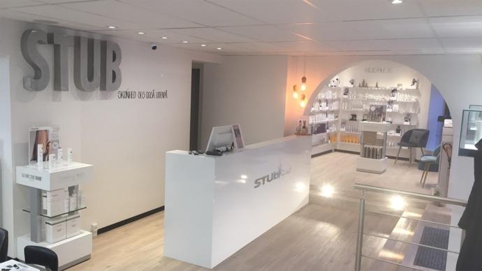 Moderne reception i en skønhedssalon med hvide vægge og stilfuld indretning.