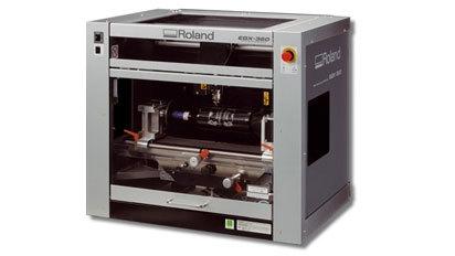 En Roland 3D-printer med åben front, der viser printerens indre mekanik og udstyr.