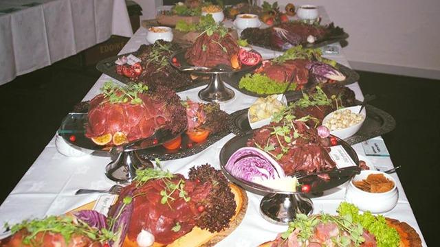 Et festligt bord dækket med flere fade af kødretter, salater og garniture til en festlig lejlighed.