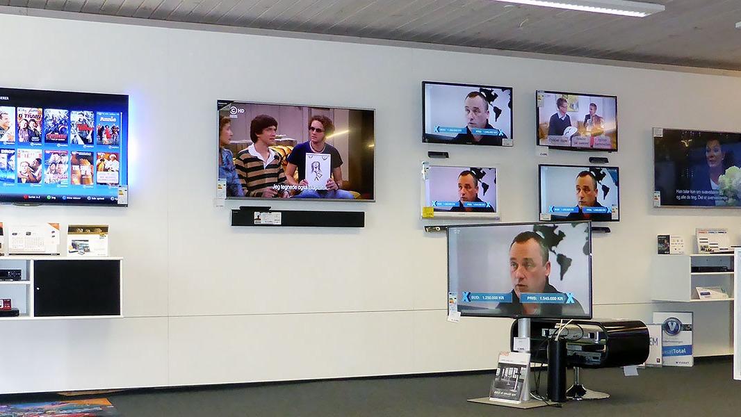 Flere fladskærms-tv'er viser forskellige programmer i en elektronikbutik.