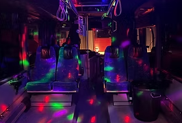 En bus med farverige lys og tomme sæder, der skaber en festlig atmosfære indeni.