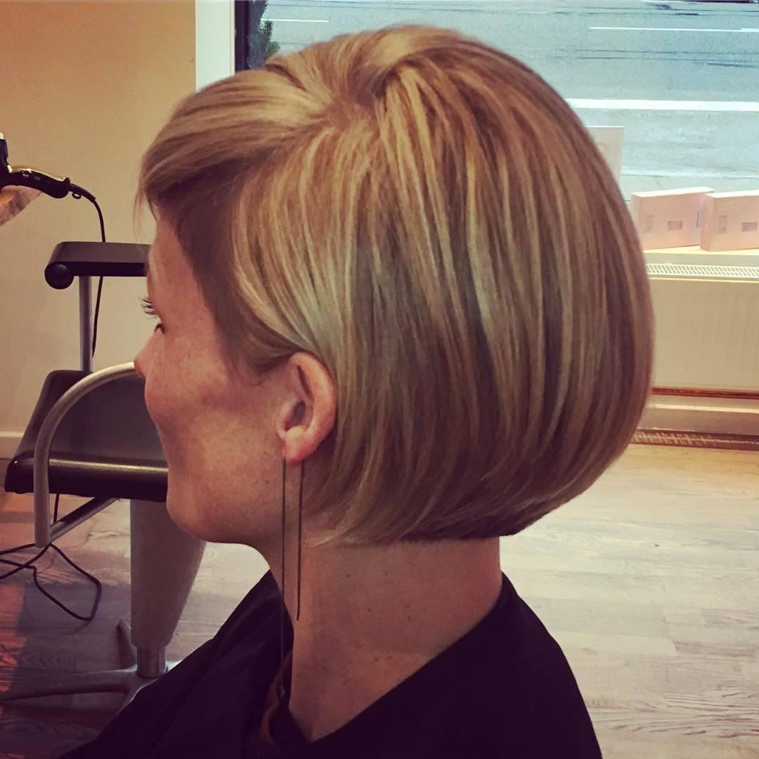 Kvinde med en moderne, kort bob-frisure i lys blond farve, siddende i en frisørsalon.